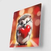 Ein niedlicher Igel, der das Herz hält Quadratische Wanduhr (Winkel)