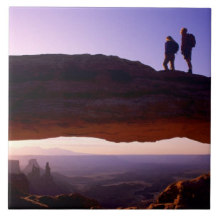Ein paar beobachten Sonnenaufgang vom Mesa Arch in Fliese