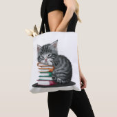 Ein schläfriges Kätzchen kuschelte sich mit einem  Tasche (Von Nahem)