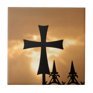 Ein Schmiedeeisenkreuz auf einem Zaun Fliese