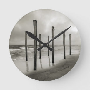 Ein sepiatfarbener Schuss alter Strandpfosten Runde Wanduhr