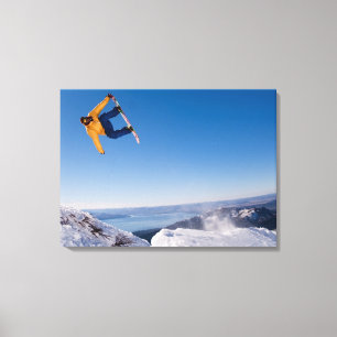 Ein Snowboarder spinnt weg einen Sprung in Leinwanddruck