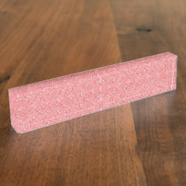 Ein Teppich mit roten und rosa Motiven ist mit ein Namensplakette
