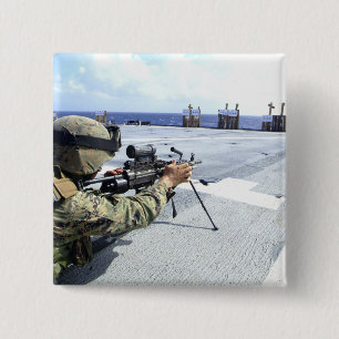 Ein US-Marinesoldat, der seine Waffe justiert Button