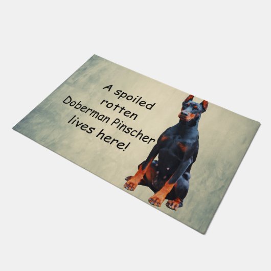 Ein verwöhnter Rotten Doberman Pinscher lebt hier Fußmatte (Schrägansicht)