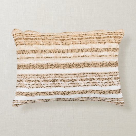 Ein verziertes, orangefarbenes und weißes Textilde Dekokissen (Vorderseite)