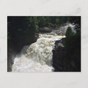 Ein Wasserfall mit Bäumen und Felsen Postkarte