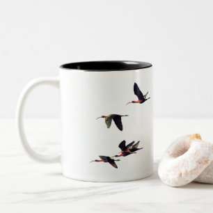 Ein Wedge von Ibises im Flug Zweifarbige Tasse