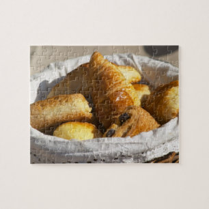 Ein Weidenkörbchen mit Croissants und Puzzle