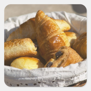 Ein Weidenkörbchen mit Croissants und Quadratischer Aufkleber