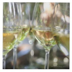 Ein Wirt gießt Gläser torrontes für Gäste an Fliese