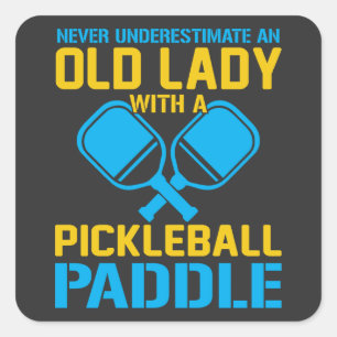 Eine alte Dame mit einem Pickleball-Paddel untersc Quadratischer Aufkleber