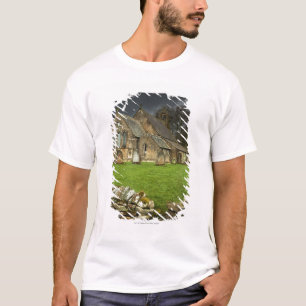 Eine alte Kirche unter einem dunklen Himmel T-Shirt