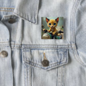 Eine gelbe Katze mit schwarzen Ohren und großen bl Button (Beispiel)