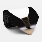 Eine Glühlampe, die in einem dunklen Raum glänzt Krawatte (Gerollt)