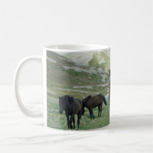 EINE GRUPPE VON PFERDEN AUF EINER BERGWEIDE KAFFEETASSE