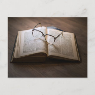 Eine Karte mit einem Buch und einer Brille