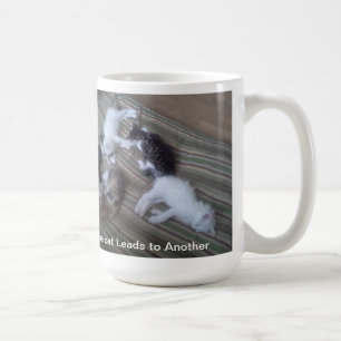 Eine Katze führt zu eine andere Tasse