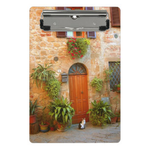 Eine Katze sucht den Eingang zum Haus in Pienza, I Mini Klemmbrett