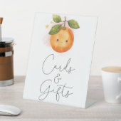 Eine kleine Süsse orangefarbene Babyduschkarten un Sockelschild (In SItu)