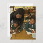 Eine Lehrerin unterstützt kleine Schulkinder in ih Postkarte (Vorne/Hinten)