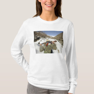 Eine Mujahadeen-Garde geht mit dem US-Militärkomma T-Shirt