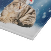 Eine Niedliche Katze, die einen Weihnachtsschnee i Schneidebrett (Ecke)