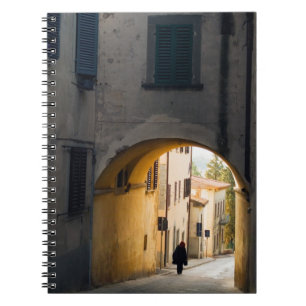 Eine Person, die unter einem Bogen geht, einen Hü Notizblock