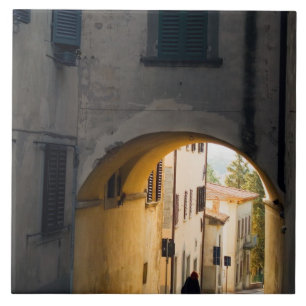 Eine Person, die unter einem Bogen geht, einen Hüg Fliese