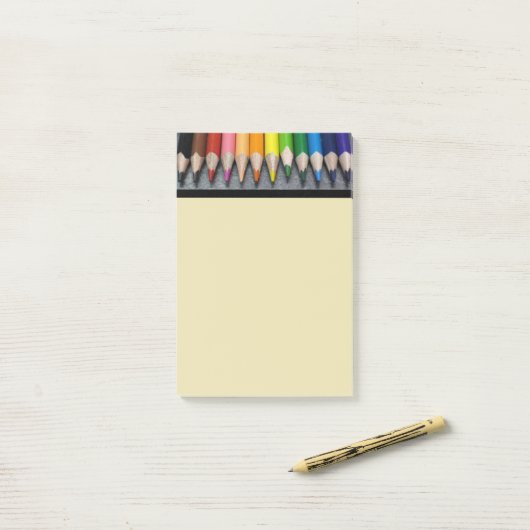 Eine Reihe farbiger Stifte. Post-it Klebezettel (Auf Schreibtisch)