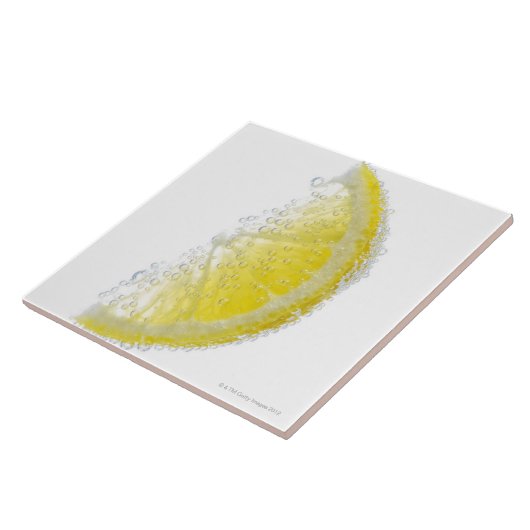 Eine saftige reife Bio Zitronenkeilfrucht versenkt Fliese (Seite)