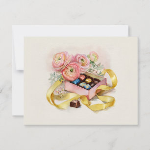 Eine Schachtel mit verschiedenen Pralinen mit rosa Feiertagskarte