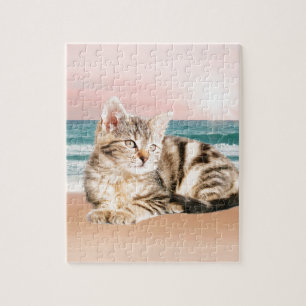 Eine süßere gestreifte Katze sitzt am Strand bei S Puzzle
