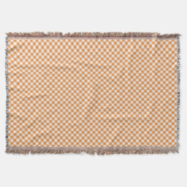Eine Tagesdecke mit kariertem Muster und orange  Decke