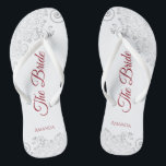 Einfaches Silver Lace & Red Script The Bride Weddi Badesandalen<br><div class="desc">Tanzen Sie die Nacht mit diesen schönen Hochzeitsflip-Flops. Sie sind für die Braut konzipiert und zeichnen sich durch ein schlichtes und dennoch elegantes Design aus, das auf weißem Hintergrund mit rot geschriebenen Schriftzeichen und extravaganten silbergrauen Spitzen- und Wirbel versehen ist. Eine schöne Art, extravagant und angemessen bleibe, während Sie Ihren...</div>