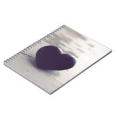 Einmaliges Lila Steinherz an einem weißen Sandstra Notizblock (Linke Seite)