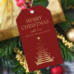 Elegant Gold Red Christmas Tree Custom Geschenkanhänger<br><div class="desc">Fügen Sie eine besondere Touch zu Ihrem Weihnachtsgeschenk in dieser Saison mit unseren eleganten Gold und Red Christmas Tree Custom Gift Tags hinzu. Diese atemberaubenden Geschenketiketten verfügen über einen wunderschön gestalteten vergoldeten Urlaubshaus auf fett rotem Hintergrund, in dem in elegantem Typografie-Schriftart "Frohe Weihnachten" geschrieben ist. Aber das ist noch nicht...</div>