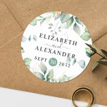 Elegant greenery eucalyptus names and wedding date runder aufkleber<br><div class="desc">This romantic and elegant floral wedding round sticker makes the perfect seal for your wedding favor, presenting a chic botanical design that features a classy bouquet of light and airy watercolor greenery and eucalyptus leaves complemented with glittery golden speckles (printed) and is easily customizable with your names and wedding date....</div>