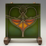 Emerald Grace Art Nouveau Fliese<br><div class="desc">Die zeitlose Eleganz der Jugendstil-Keramik "Emerald Grace Art Nouveau Tile", ein atemberaubendes Stück, das die Geschmeidigkeit und Bio Schönheit der Jugendstil-Bewegung verkörpert, verleiht Ihrer Zuhause die Note. Diese Keramik, gedruckt von Zazzle, zeichnet sich durch ein faszinierendes Design mit fließenden Linien und ein zentrales Motiv in satten Orange- und Grüntönen aus....</div>
