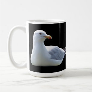 Entspannte Möwe ruht auf sauberem schwarzen Hinter Kaffeetasse