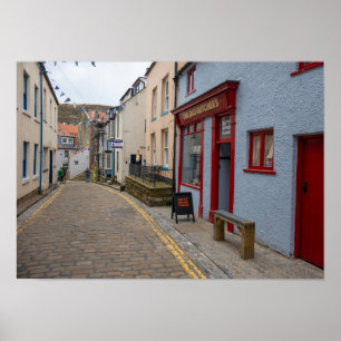Entzückende gepflasterte Straße im Dorf Staithes Poster