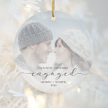 Erste Weihnachten Verlobte Custom Foto Grau Script Keramik Ornament<br><div class="desc">Gedenken Sie Ihre Verlobung mit diesem schönen modernen Sakraldekor. Der kohlegraue Text lautet "Unser erstes Weihnachtsfest verlobt", mit dem Wort "verlobt" in eleganter Schrift, die vor und nach den Wimpern schwebt. Ersetzen Sie das Beispielbild durch Ihr Lieblings-Foto, und fügen Sie Ihre Namen und das Jahr hinzu. Mithilfe eines Farbverlaufsefilters wird...</div>