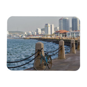 Fahrrad am Wasser mit der Skyline der Stadt Yantai Magnet