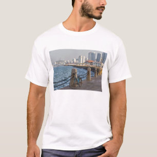 Fahrrad am Wasser mit der Skyline der Stadt Yantai T-Shirt