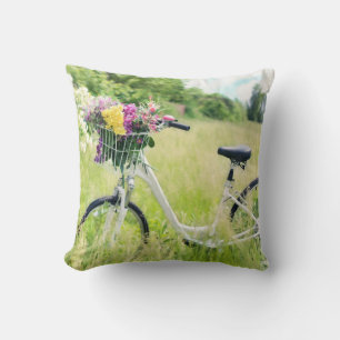 Fahrrad mit Korb der Blume auf der Wiese Kissen