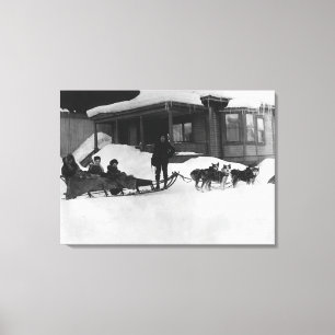 Familie, die durch Hundeschlitten in Alaska reist Leinwanddruck