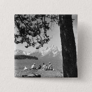 Familie, die Picknick durch Seeberge hat Button