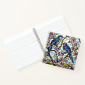 Farbenfrohe, festgeklemmte Glasvögel auf blühenden Notizblock (Innenseite)