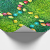 Farbenfrohe, gemalte Eier im Gras, Ostereier im so Geschenkpapier (Ecke)