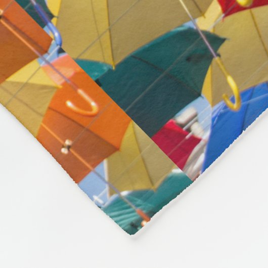 Farbenfrohe Regenschirme in himmelblau-orange rot Fleecedecke (Ecke)